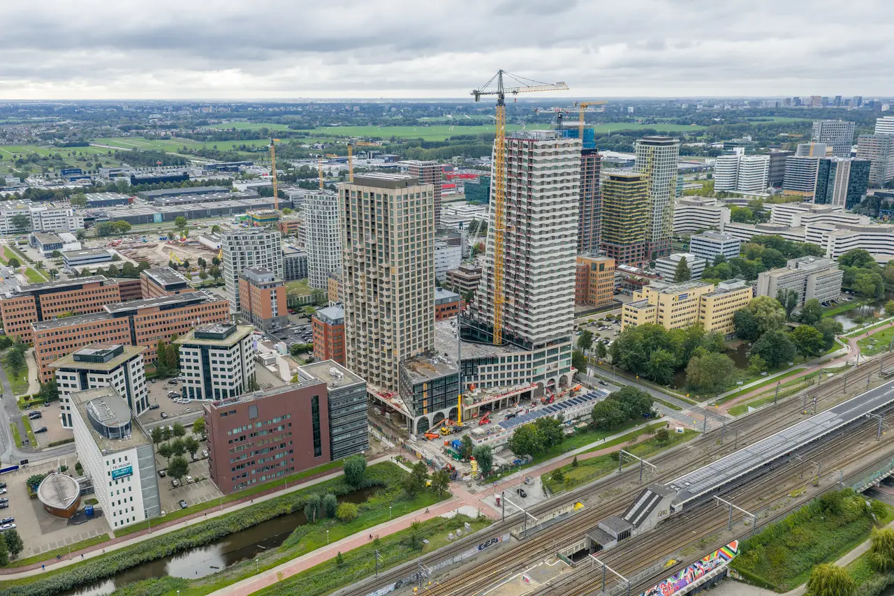 Luchtfoto van Amsterdam Zuidoost rond de Karspeldreef met nieuwbouwtorens en het spoor